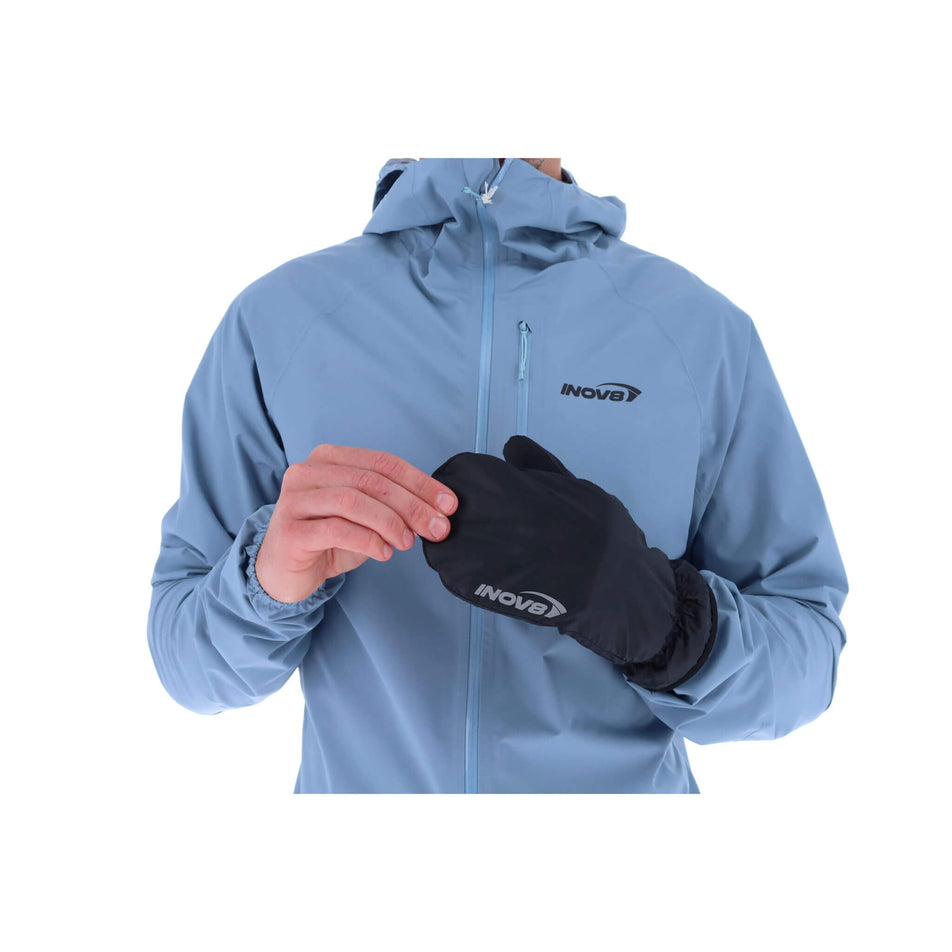 A model wearing the left glove from a pair of INOV8 Unisex Waterproof Overmitts in the Black colourway.  (8523660066978)