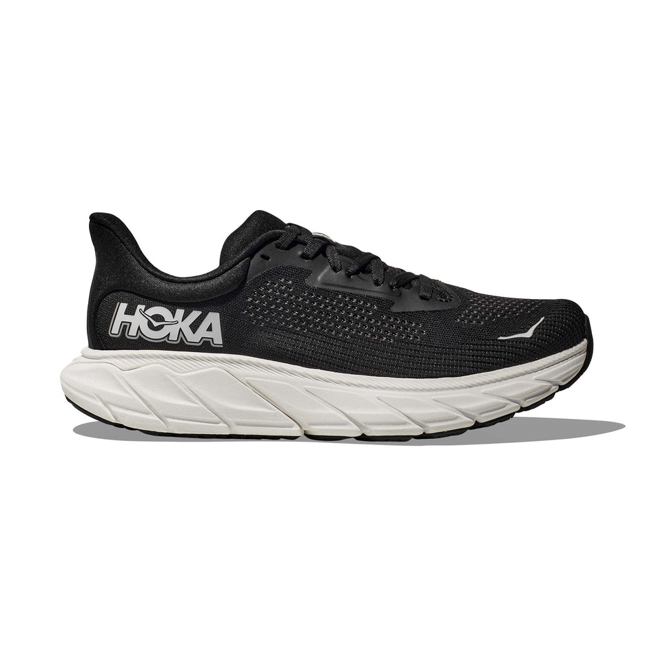 Lateral side of the right shoe from a pair of HOKA Women's Arahi 7 Wide Running Shoes in the Black/White colourway (8146247123106)