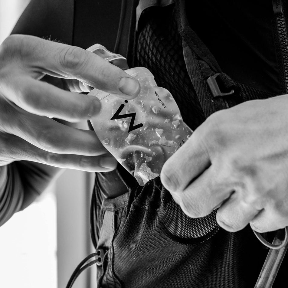 A model demonstrating that a Maurten Gelflask can be stored in the chest pocket of a hydration vest. (8560927899810)