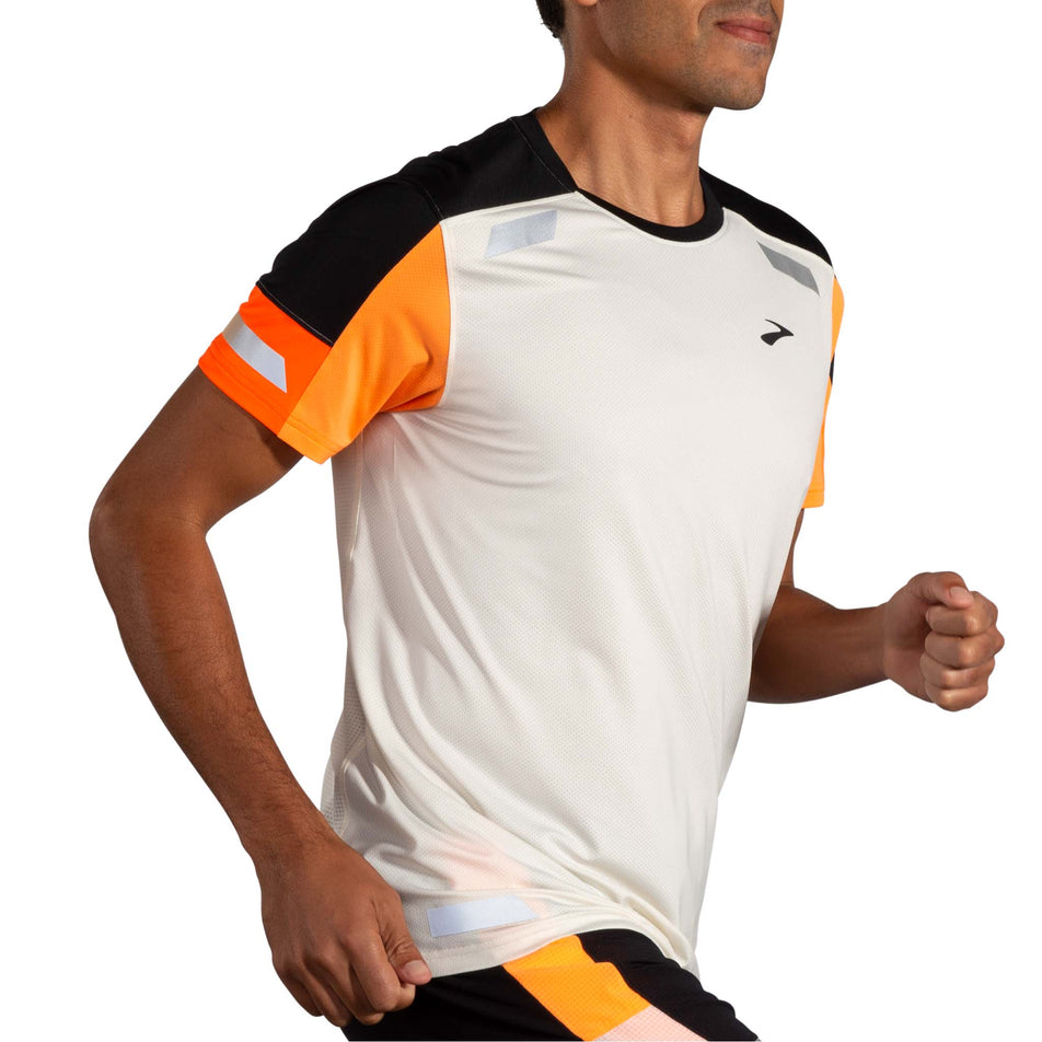 Front view of a model wearing the Brooks Men's Run Visible Short Sleeve 2.0 in the Ecru/Fluoro Flash/Black colourway. Model is also wearing Brooks shorts. (8499431800994)