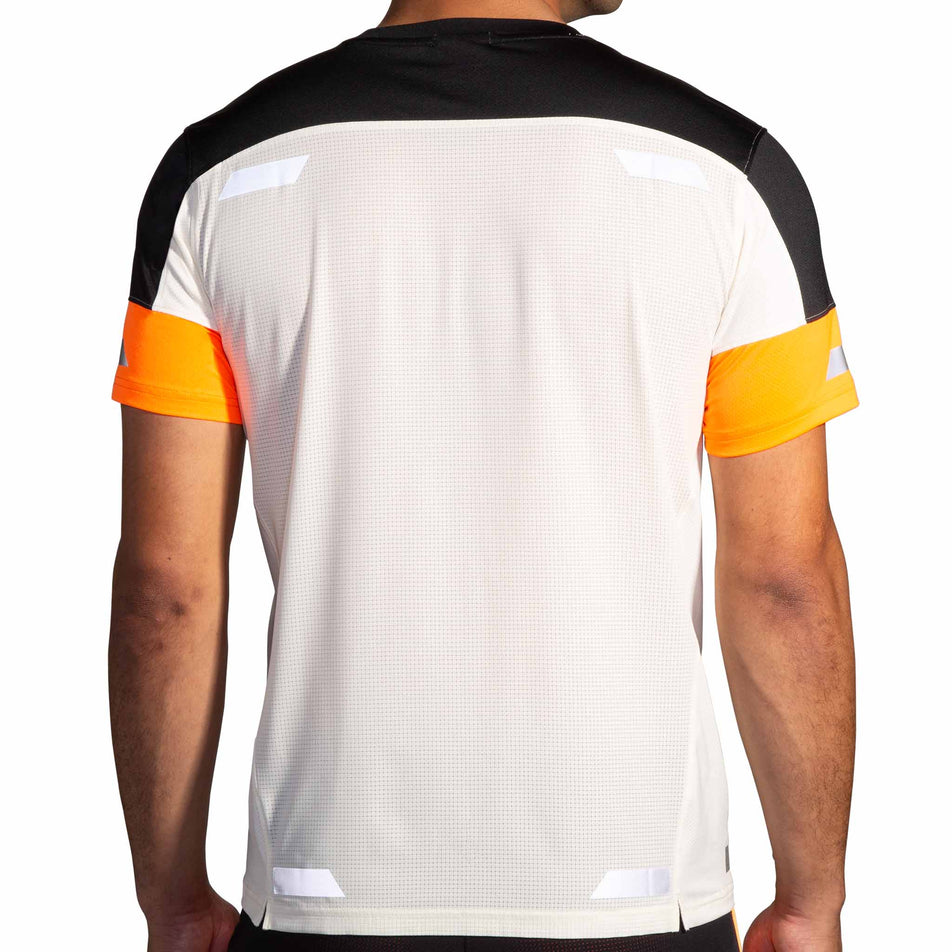 Back view of a model wearing the Brooks Men's Run Visible Short Sleeve 2.0 in the Ecru/Fluoro Flash/Black colourway. Model is also wearing Brooks shorts. (8499431800994)