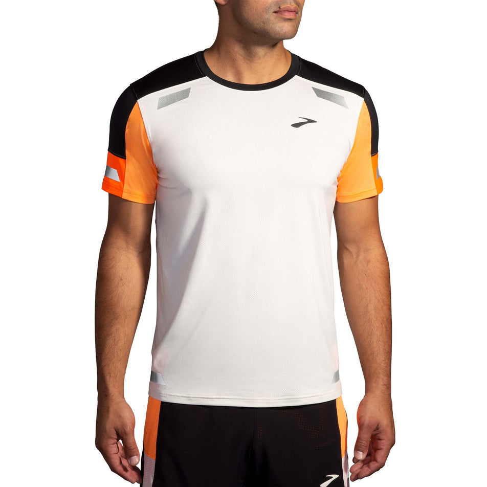 Front view of a model wearing the Brooks Men's Run Visible Short Sleeve 2.0 in the Ecru/Fluoro Flash/Black colourway. Model is also wearing Brooks shorts.(8499431800994)