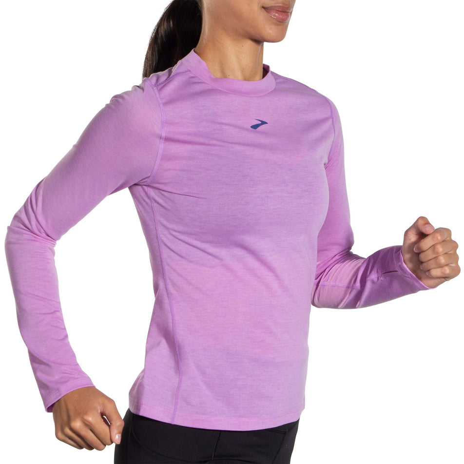 Right-side view of model wearing a Brooks Women's High Point Long Sleeve Top in the Bright Purple colourway. Model is in a running pose. (8037740609698)