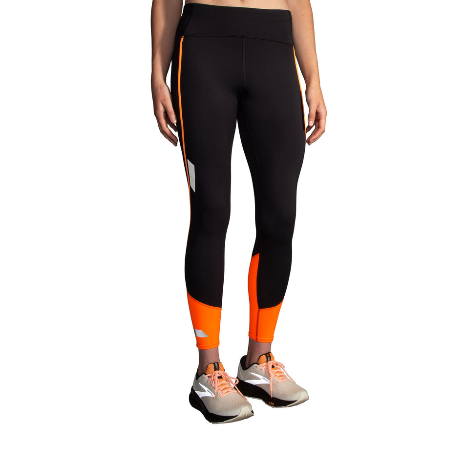 Front view of a model wearing the Brooks Women's Run Visible Tight 2.0 in the Black/Fluoro Flash colourway. Model is also wearing Brooks shoes. (8499453362338)