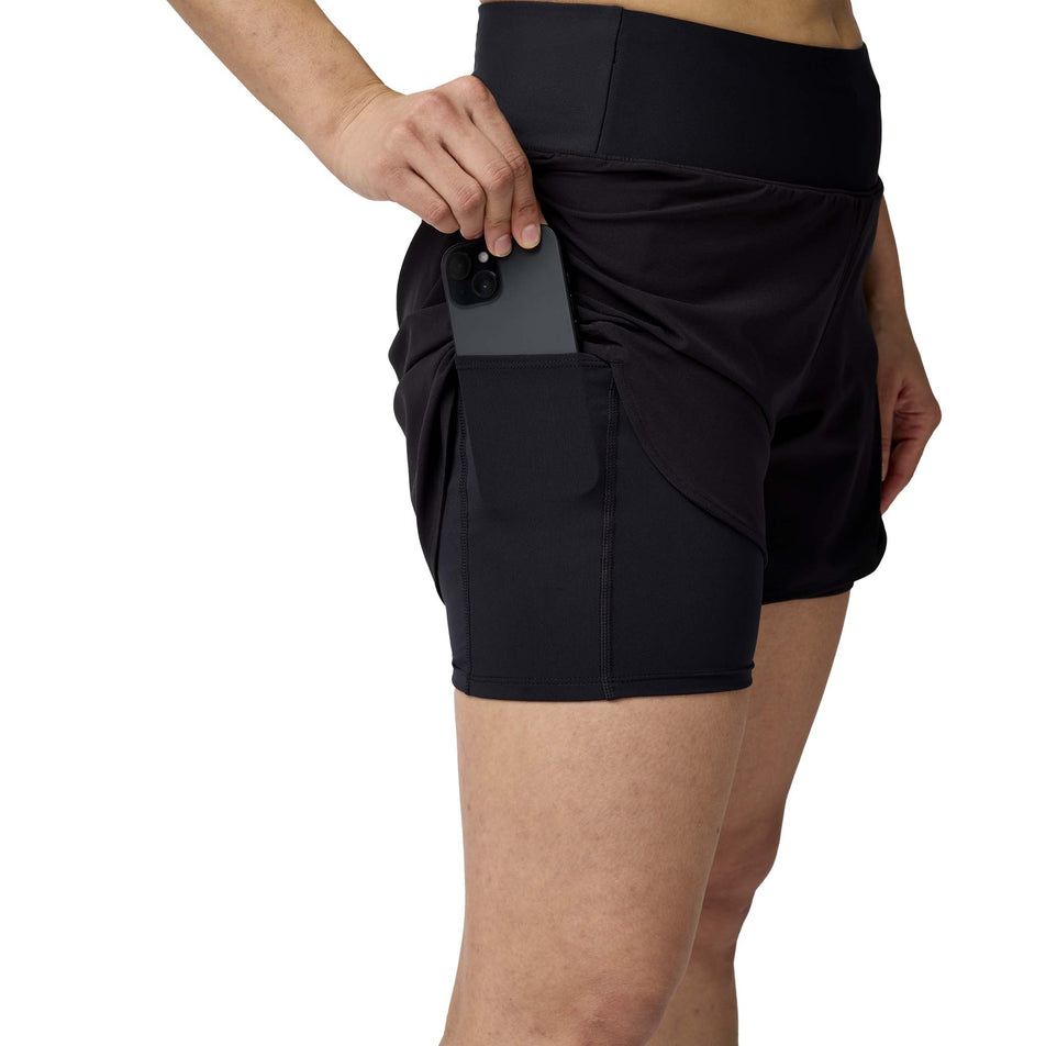 A model demonstrating the stash pocket on the side of the liner on the Brooks Women's Chaser 5