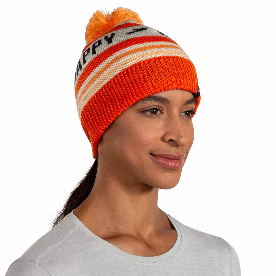 Front view of a model wearing the Brooks Unisex Heritage Pom Beanie in the Fluoro Flash Run Happy colourway.  (8511194333346)