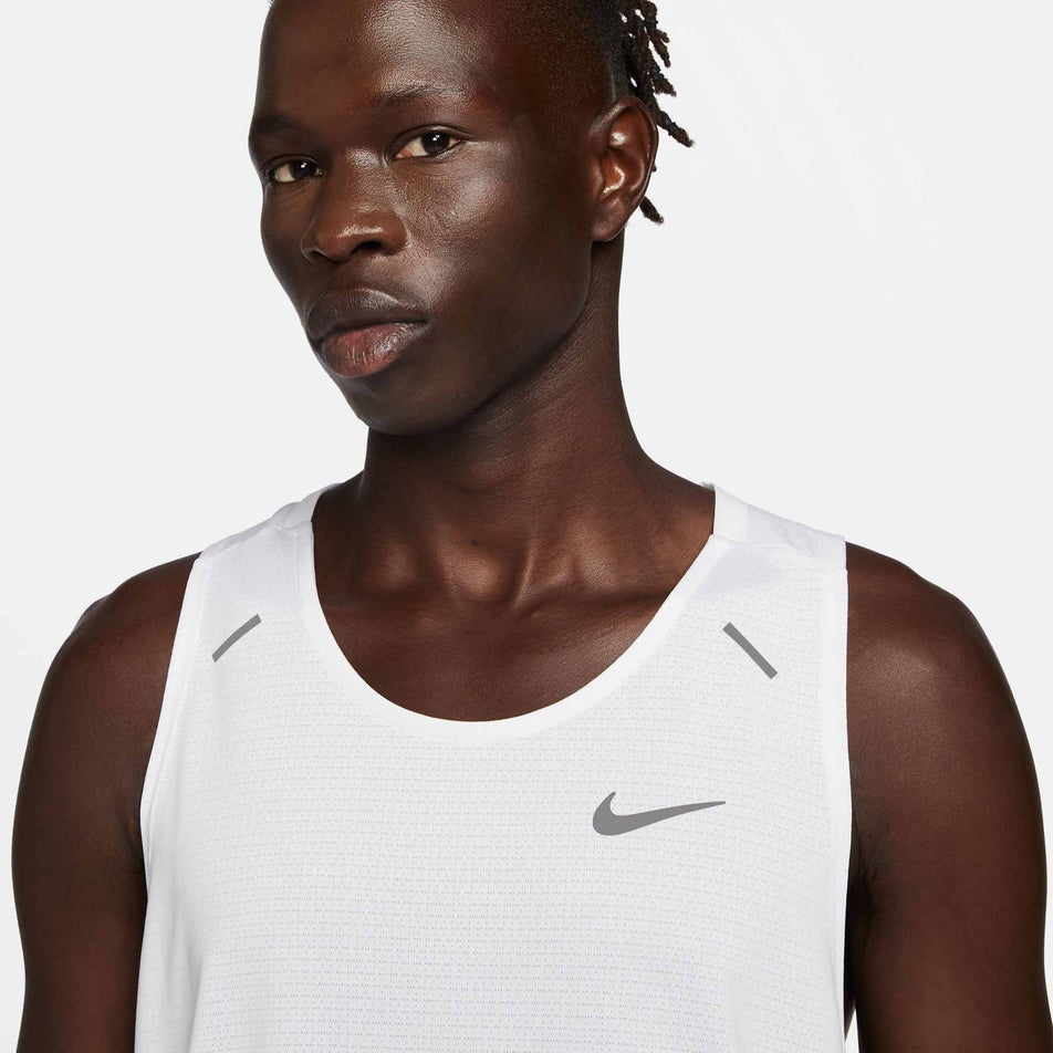 Close=up front view of a model wearing a Nike Men's Rise 365 Dri-FIT Running Tank in the White/Reflective Silv colourway. Only the upper section of the tank can be seen in the image. (8409892651170)