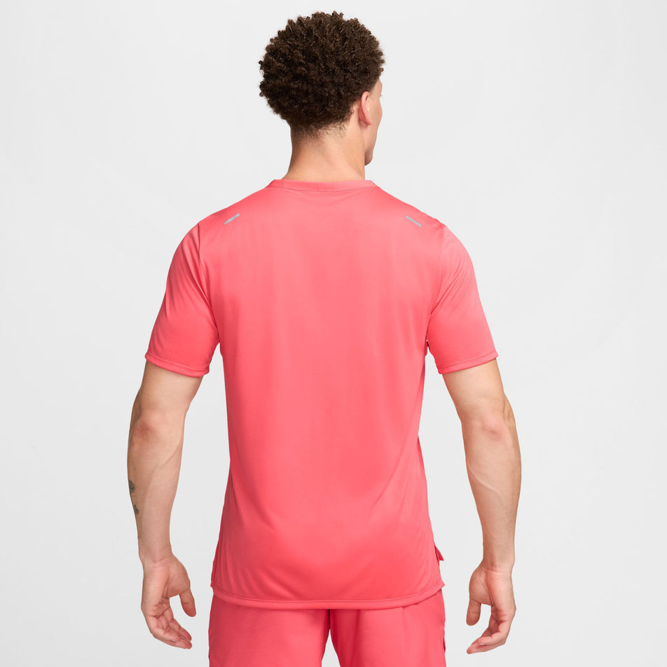 Back view of a model wearing a Nike Men's Rise 365 Dri-FIT Short-Sleeve Running Top in the Aster Pink/Reflective Silv colourway. Model is also wearing Nike running shorts. (8399204548770)