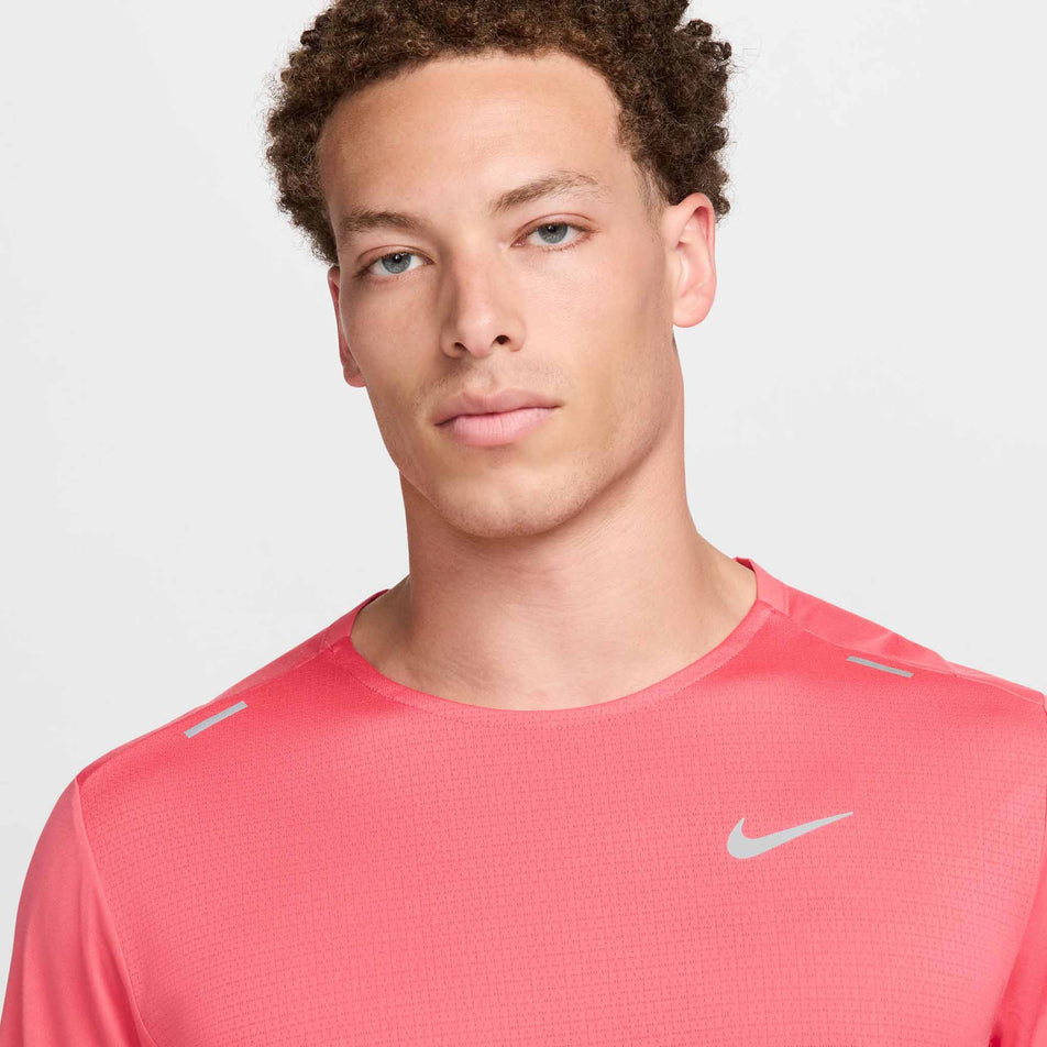 Close-up front view of a model wearing a Nike Men's Rise 365 Dri-FIT Short-Sleeve Running Top in the Aster Pink/Reflective Silv colourway. Only the upper part of the top can be seen in the image. (8399204548770)