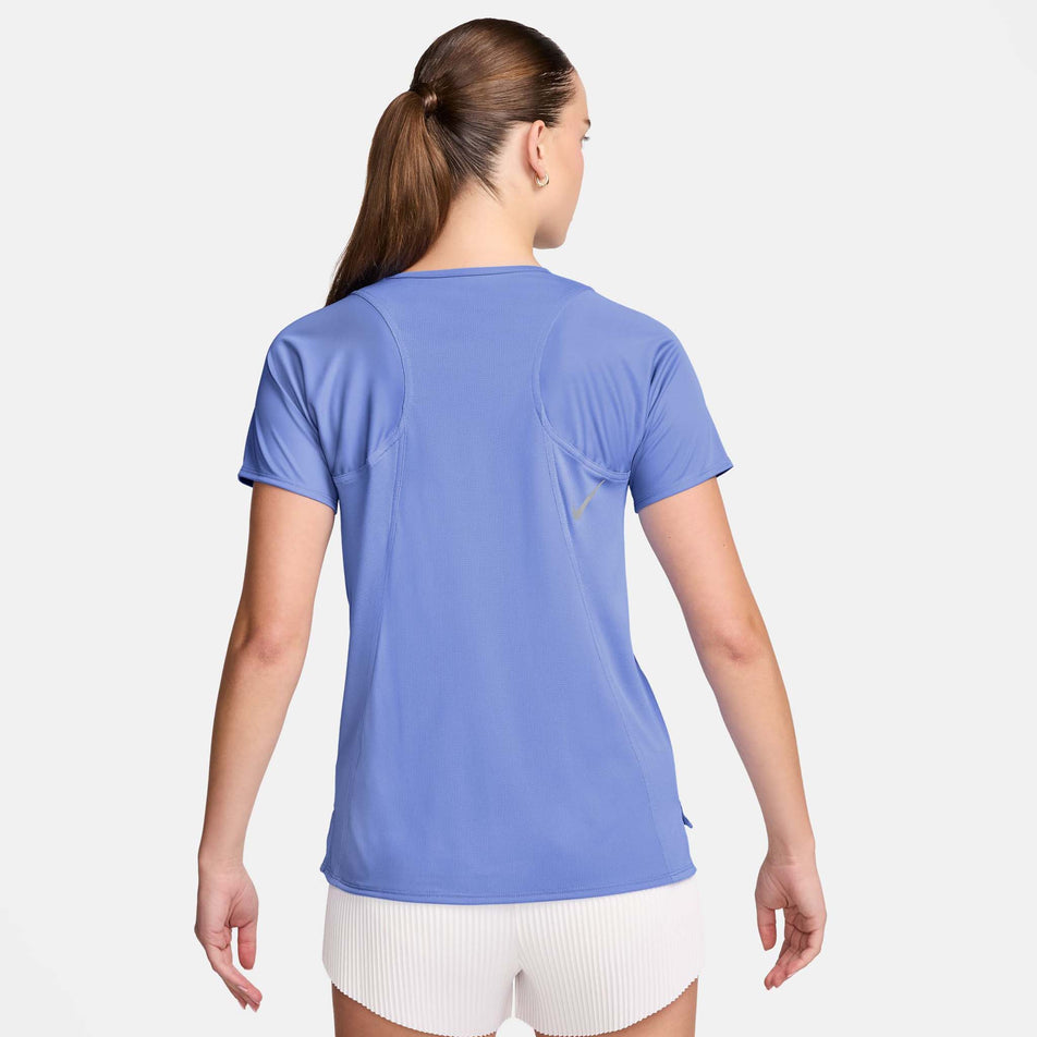 Back view of a model wearing a Nike Women's Dri-FIT Race Short-Sleeve Running Top in the Royal Pulse/Reflective Silver colourway. Model is also wearing White Nike shorts. (8495625240738)