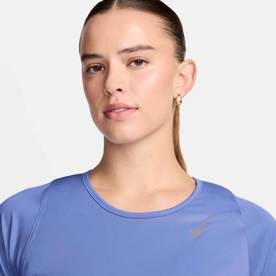 Close-up view of the neckline of a model wearing a Nike Women's Dri-FIT Race Short-Sleeve Running Top in the Royal Pulse/Reflective Silver colourway. (8495625240738)