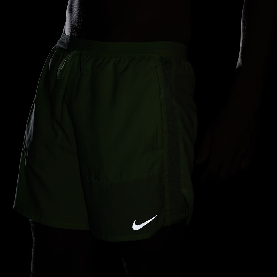 The reflective Nike SWOOSH on the front of a pair of Nike Men's Stride Dri-FIT 5