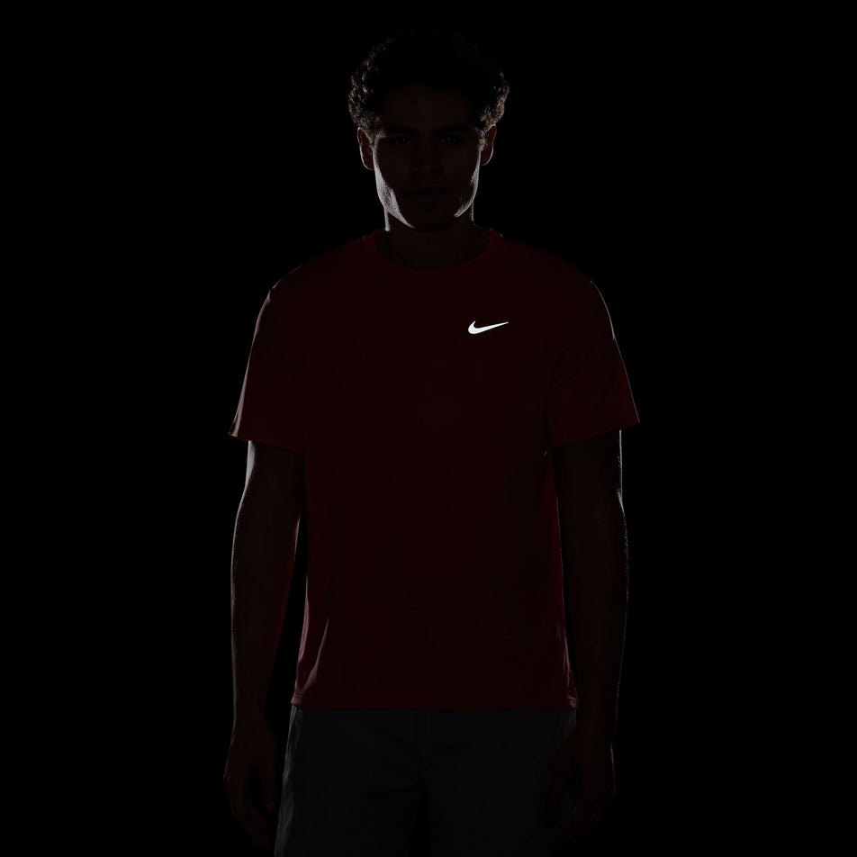 The reflective Swoosh on the front of the Nike Men's Miler Dri-FIT UV Short-Sleeve Running Top in the LT Wild Mango/Reflective Silv colourway. (8497716560034)