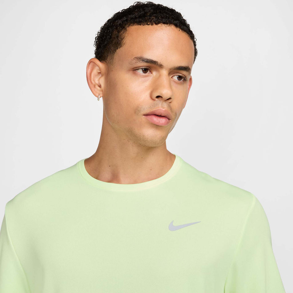 Close up view of the chest on the Nike Men's Miler Dri-FIT UV Short-Sleeve Running Top in the Barely Volt/Reflective Silver colourway. (8560184459426)