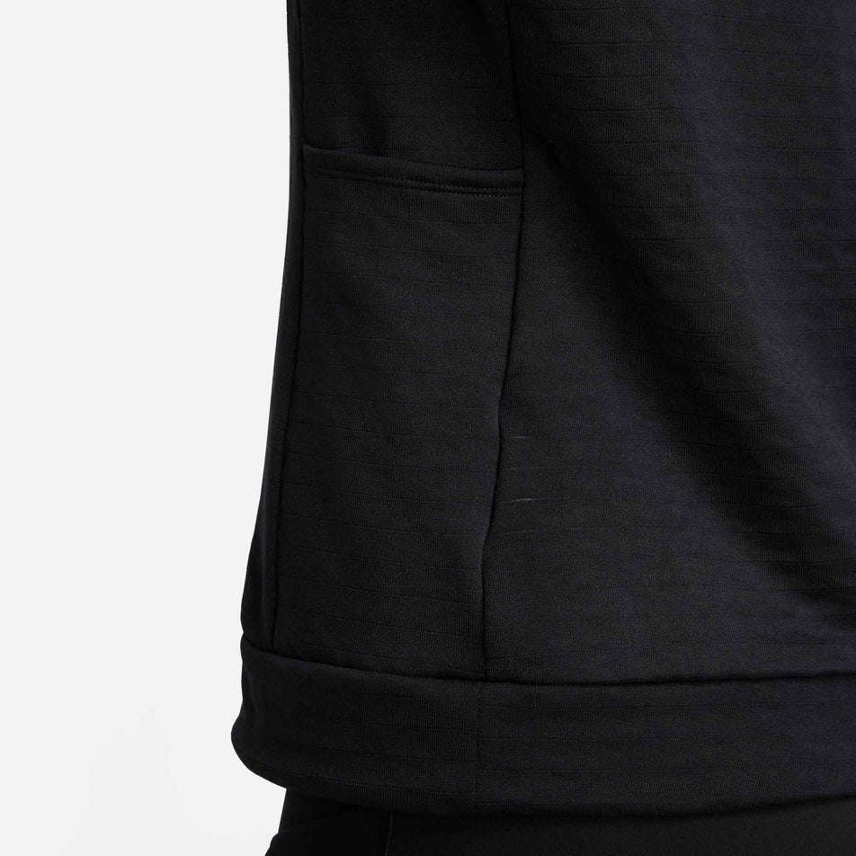 Close-up view of a pocket on the side of the Nike Women's Swift Element Therma-FIT Turtleneck Running Top in the Black/Reflective Silver colourway.  (8497637752994)