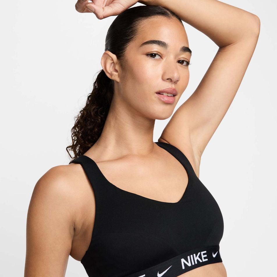 Close-up front view of a model wearing a Nike  Women's Indy High Support Padded Adjustable Sports Bra in the Black/Black/White colourway.(8495571435682)