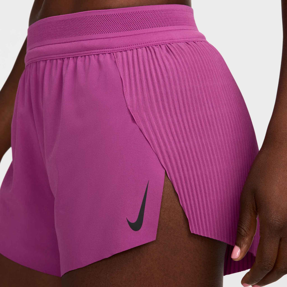 Side view of a model wearing a pair of Nike Women's AeroSwift Dri-FIT ADV Mid-Rise Brief-Lined 3