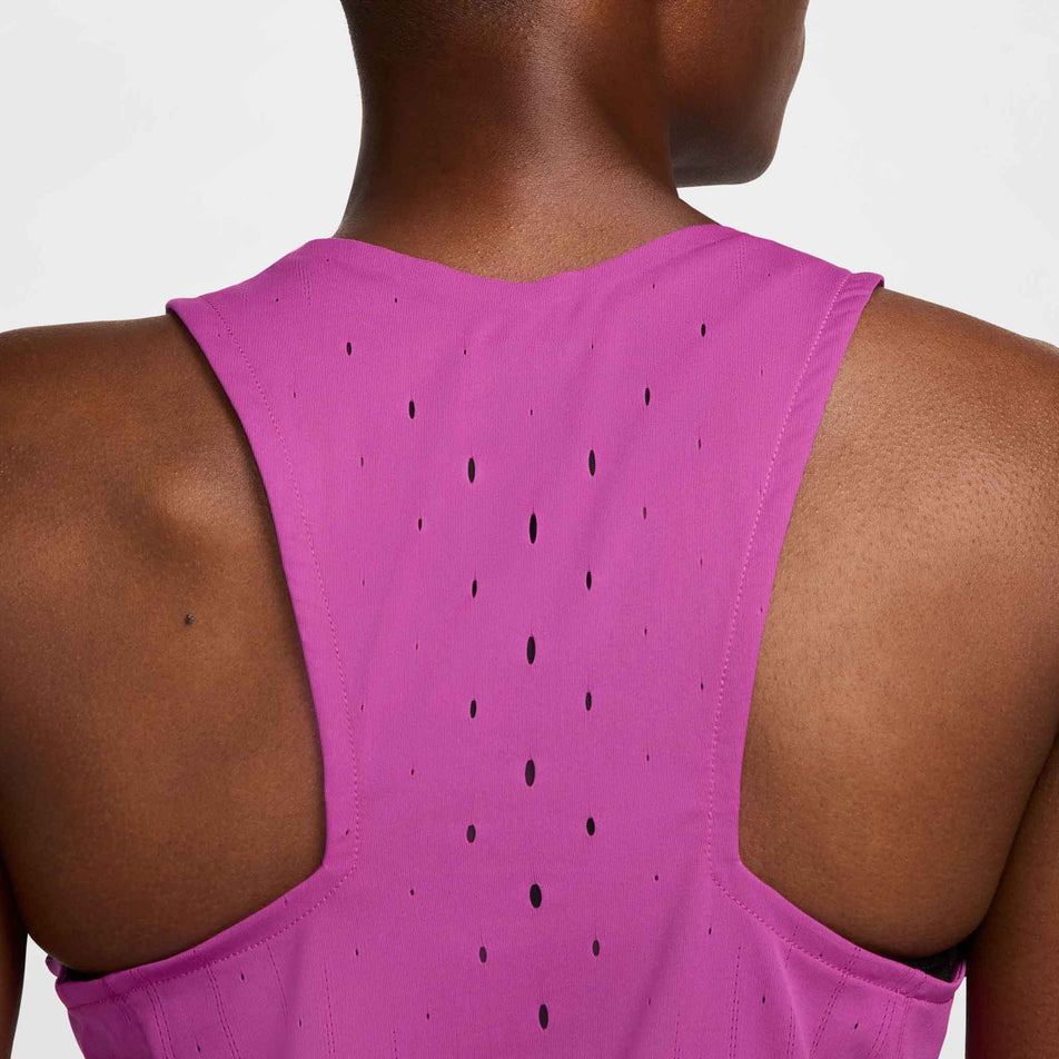 Close-up of the back-front part of a Nike Women's AeroSwift Dri-FIT ADV Running Singlet in the Hot Fuchsia/Black colourway. The top is being worn by a model. (8492375015586)