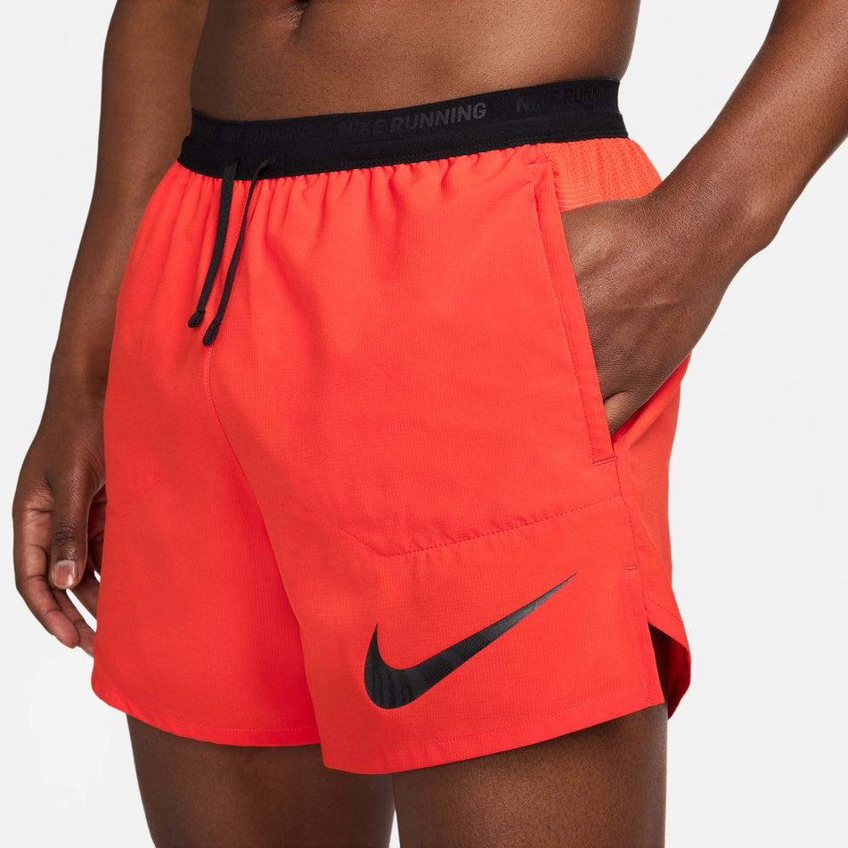 Side front view of a model wearing a pair of Nike Men's Flex Stride Run Energy 5