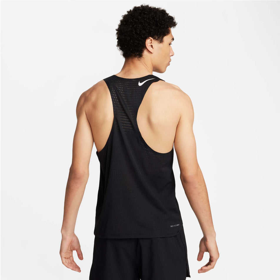 Back view of a model wearing a Nike Men's AeroSwift Dri-FIT ADV Running Singlet in the Black/Summit White colourway. Model is also wearing Nike shorts. (8393096462498)