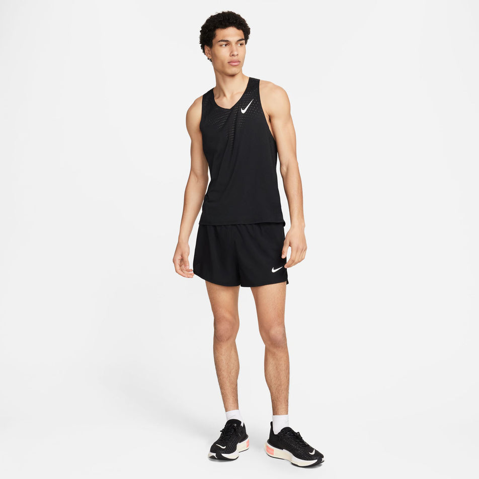 Front view of a model wearing a Nike Men's AeroSwift Dri-FIT ADV Running Singlet in the Black/Summit White colourway. Model is also wearing Nike shorts, socks and shoes. (8393096462498)