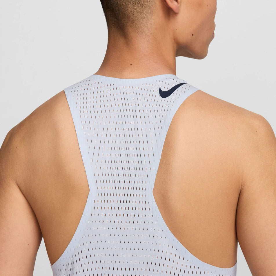 Close-up back view of a model wearing a Nike Men's AeroSwift Dri-FIT ADV Running Singlet in the Football Grey/Dark Obsidian colourway. Only the upper part of the singlet can be seen in the image. (8399202058402)