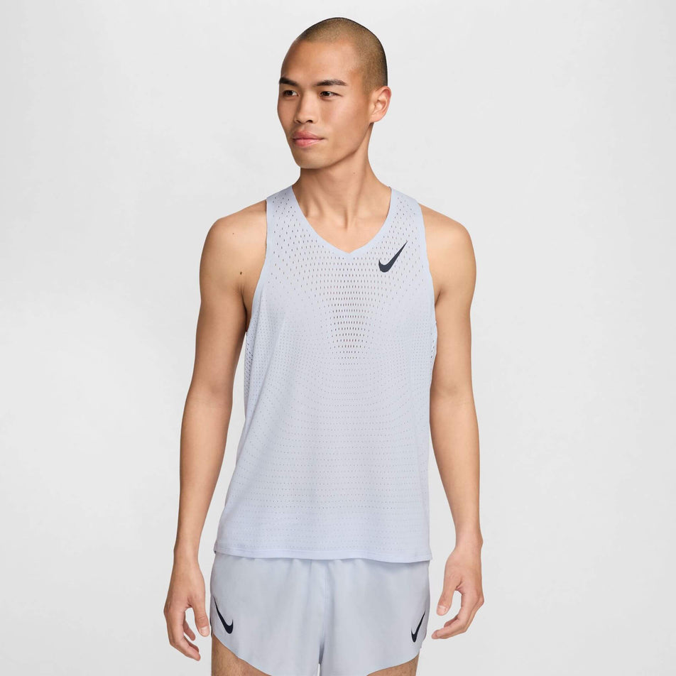 Front view of a model wearing a Nike Men's AeroSwift Dri-FIT ADV Running Singlet in the Football Grey/Dark Obsidian colourway. Model is also wearing Nike running shorts. (8399202058402)