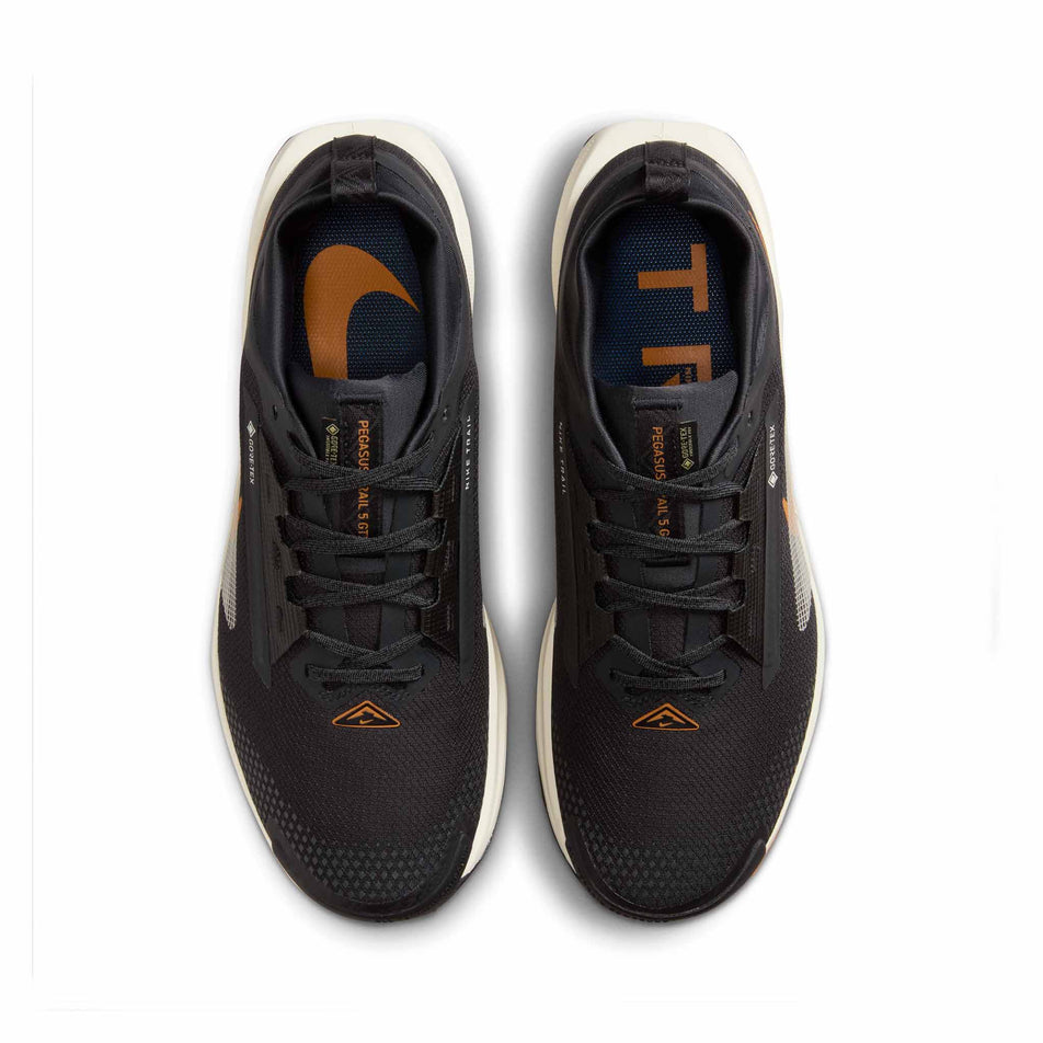 The uppers on a pair of Nike Men's Pegasus Trail 5 GORE-TEX Waterproof Trail Running Shoes in the Off Noir/Pale Ivory-Black-Monarch colourway. (8558401847458)