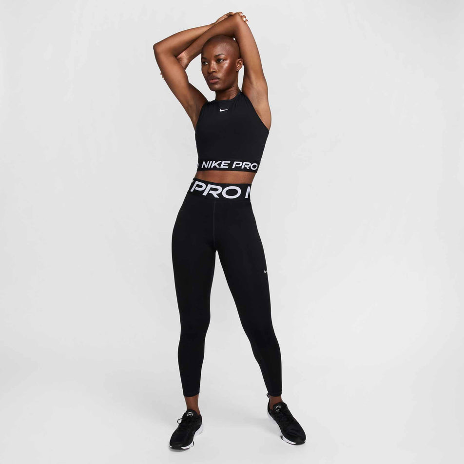 Front view of a model wearing a pair of Nike Women's Pro Sculpt High-Waisted Full-Length Leggings in the Black/White colourway. Model is also wearing a Nike top and Nike shoes. (8399168143522)