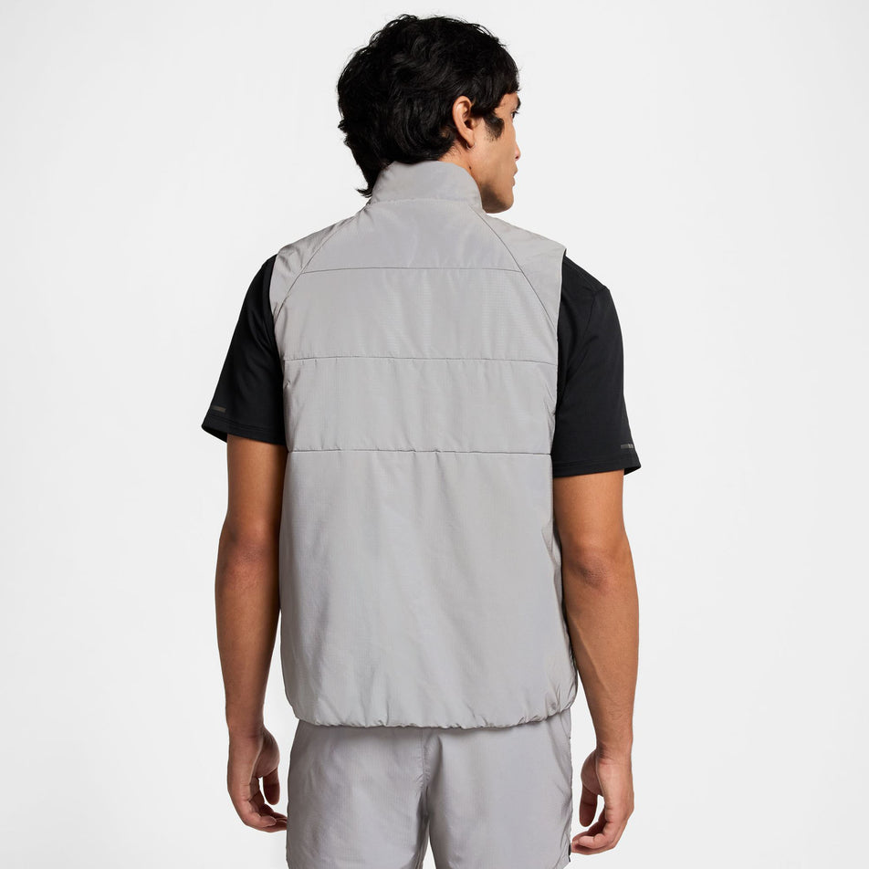 Back view of a model wearing the Nike Men's Therma-FIT Running Division ADV Running Vest. Model is also wearing shorts and a t-shirt. (8497736941730)