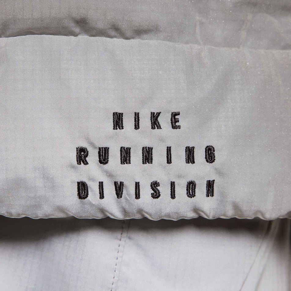 The Nike Running Division branding on the Nike Men's Therma-FIT Running Division ADV Running Vest. (8497736941730)