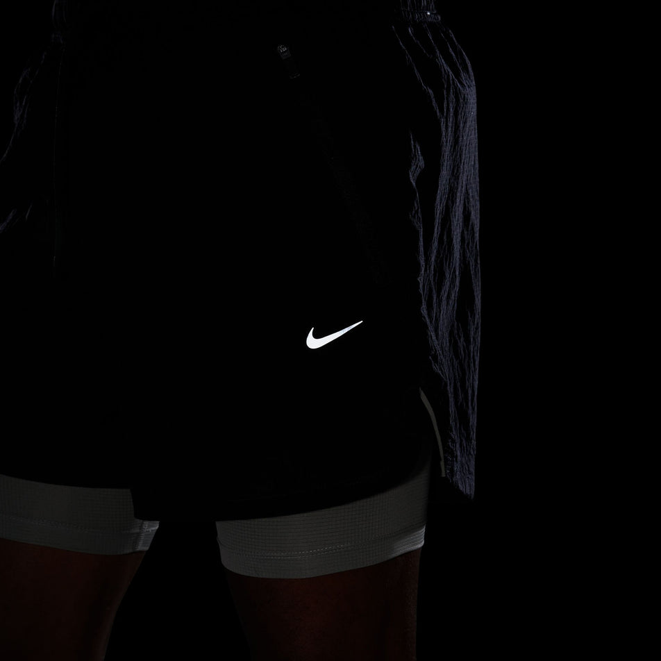 The reflective Nike Swoosh logo on the front left side of the Nike Men's Dri-FIT Water-Repellent Running Division Stride 5