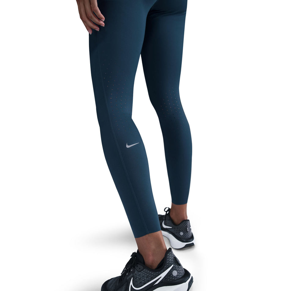 Angled view of the back of the Nike Women's Swift Dri-FIT High Rise 7/8 Running Tights in the Armory Navy/Reflective Silver colourway. (8560458563746)