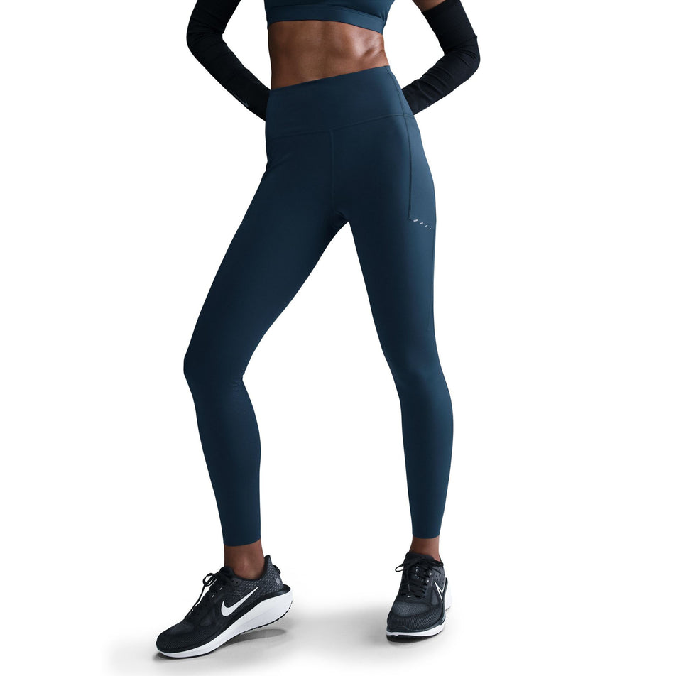 Front view of a model wearing a pair of Nike Women's Swift Dri-FIT High Rise 7/8 Running Tights in the Armory Navy/Reflective Silver colourway. (8560458563746)