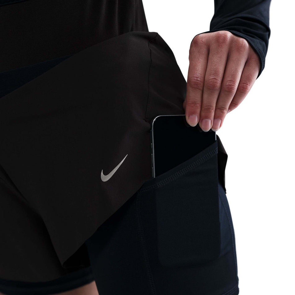 Close up view of the drop-in pocket on the inner short on the left side of the Nike Women's Swift Dri-FIT Mid-Rise 2-in-1 Running Shorts in the Black/Reflective Silver colourway. (8560446046370)