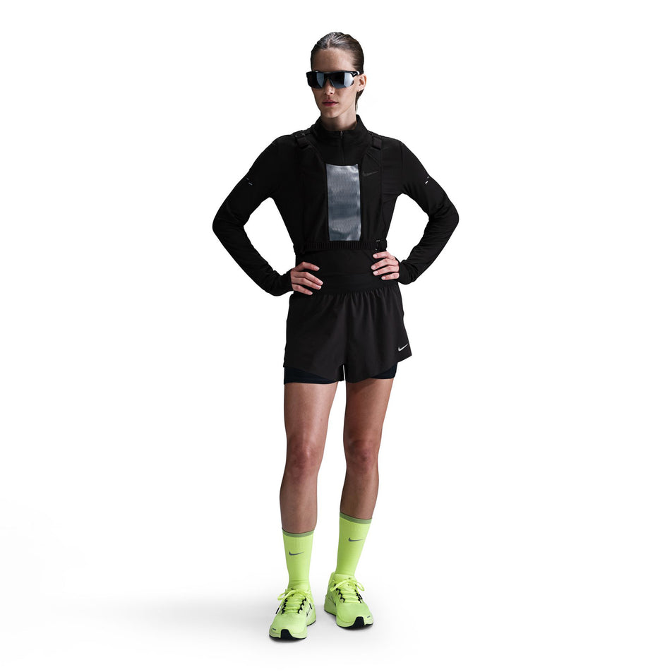 Front view of a model wearing a pair of Nike Women's Swift Dri-FIT Mid-Rise 2-in-1 Running Shorts in the Black/Reflective Silver colourway. (8560446046370)