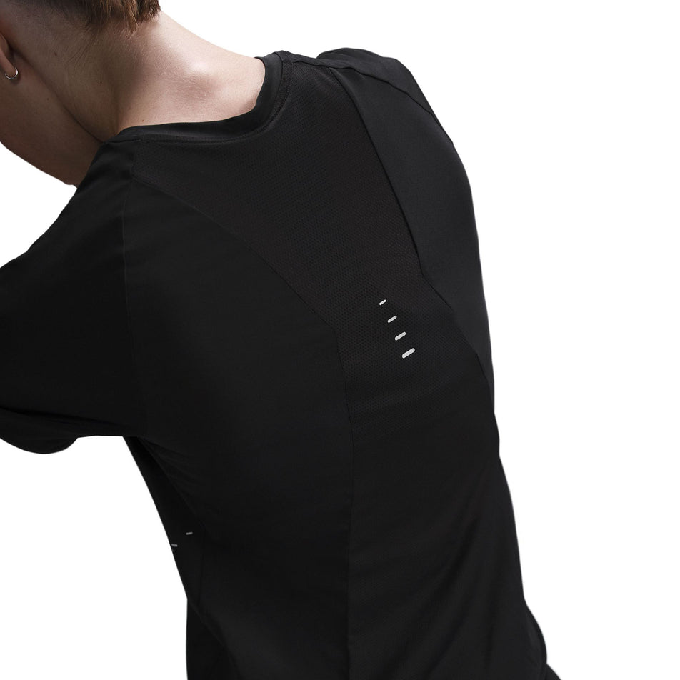 Back view of a model wearing a Nike Women's Swift Dri-FIT Short-Sleeve Running Top in the Black/Reflective Silver colourway.  (8560479404194)