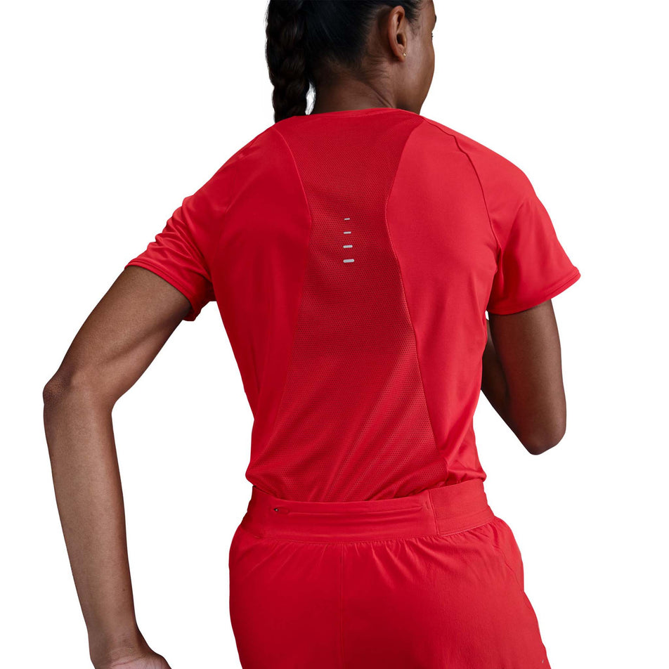 Back view of a model wearing a Nike Women's Swift Dri-FIT Short-Sleeve Running Top in the Light Crimson/Reflective Silver. (8560485662882)