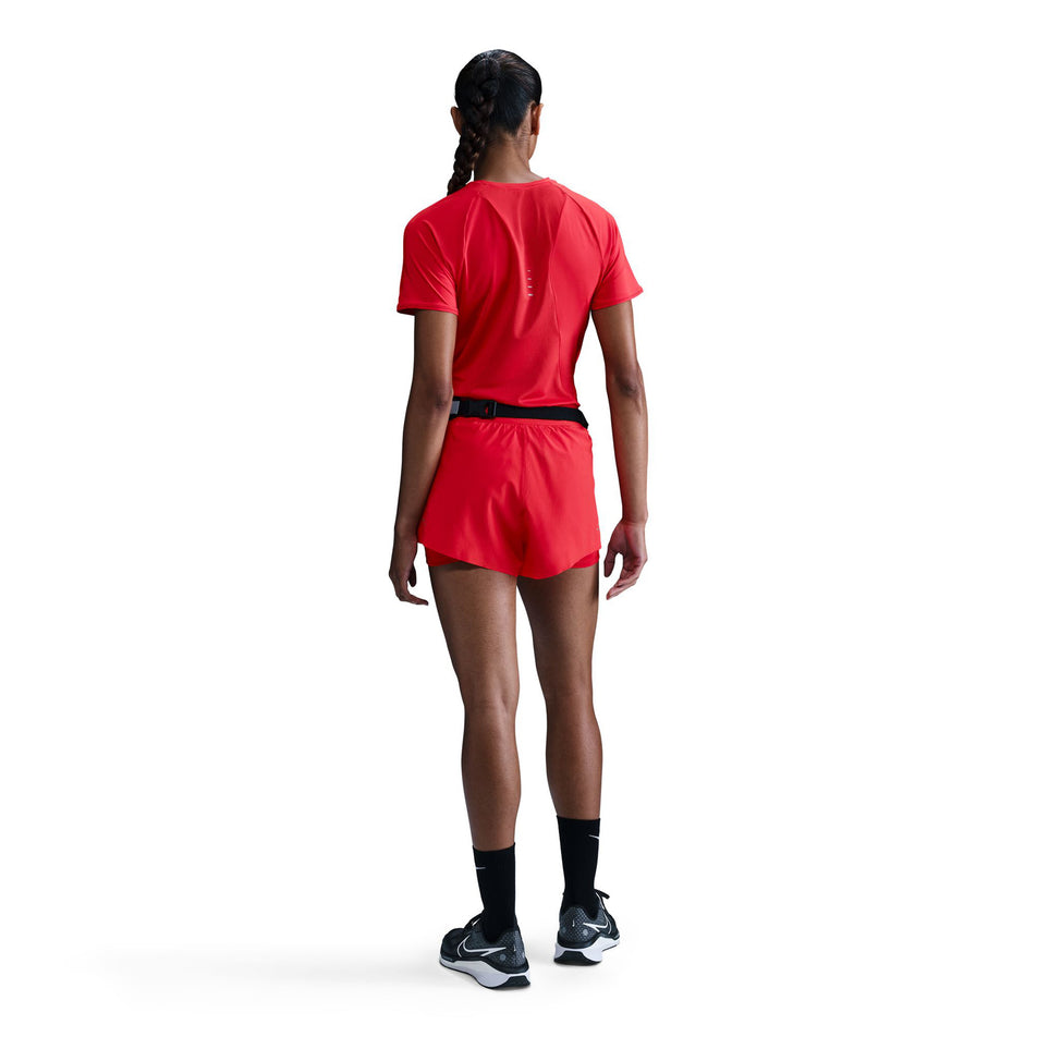 Back view of a model wearing a Nike Women's Swift Dri-FIT Short-Sleeve Running Top in the Light Crimson/Reflective Silver.  (8560485662882)