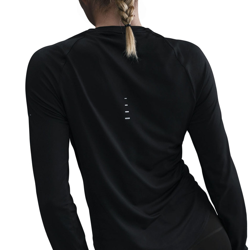 Back view of a model wearing a Nike Women's Swift Dri-FIT UV Long-Sleeve Crew Running Top in the Black/Reflective Silver colourway. (8560750264482)