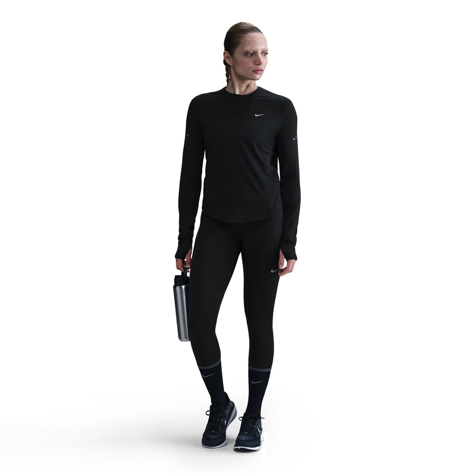 Front view of a model wearing a Nike Women's Swift Dri-FIT UV Long-Sleeve Crew Running Top in the Black/Reflective Silver colourway. (8560750264482)