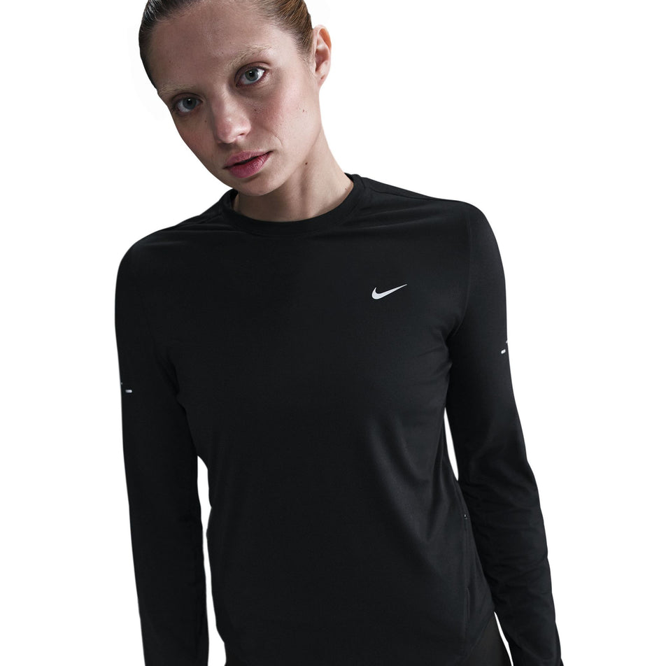 Front view of a model wearing a Nike Women's Swift Dri-FIT UV Long-Sleeve Crew Running Top in the Black/Reflective Silver colourway. (8560750264482)