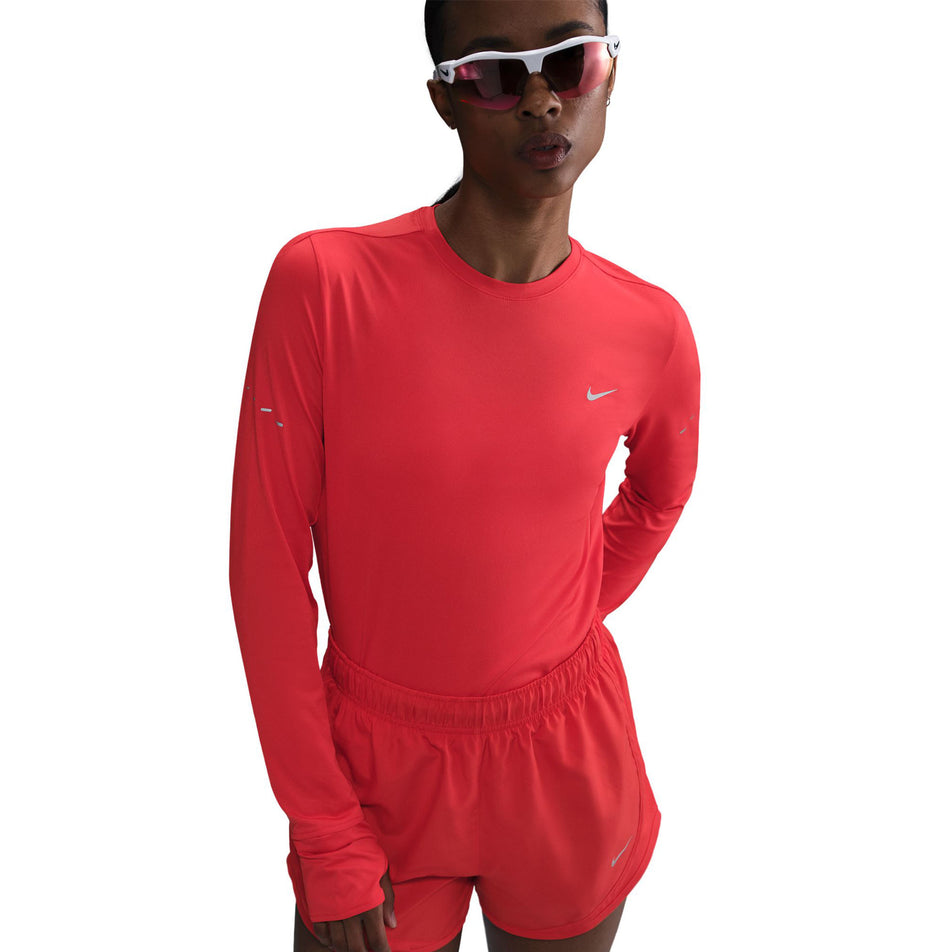 Front view of a model wearing a Nike Women's Swift Dri-FIT UV Long-Sleeve Crew Running Top in the Light Crimson/Reflective Silver colourway. (8560789553314)