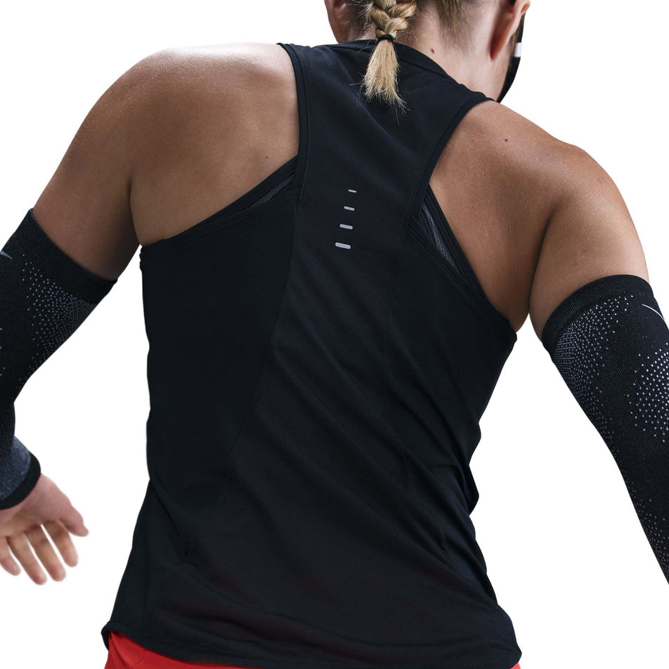 Back view of a model wearing a Nike Women's Swift Dri-FIT Running Tank Top in the Black/Reflective Silver colourway. (8560470524066)