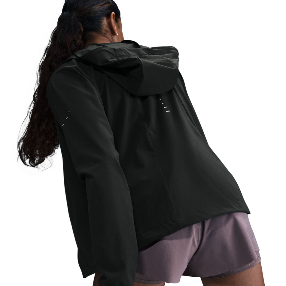 Back view of a model wearing a Nike Women's Swift Repel Packable Running Jacket in the Black/Reflective Silver colourway.  (8560817635490)