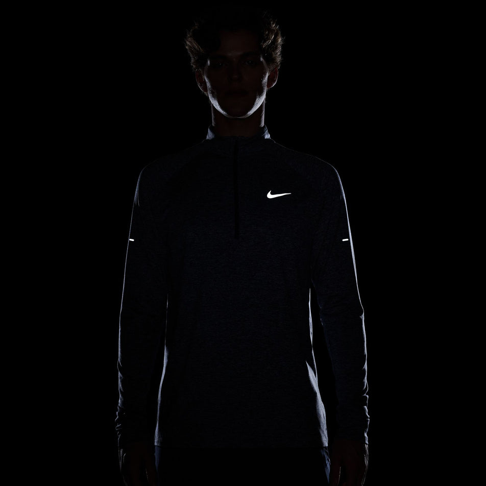 The reflective Nike SMOOSH on the front of the Nike Men's Stride Dri-FIT Half-Zip Midlayer in the Thunder Blue/Heather/Reflective Silver colourway. (8560377069730)