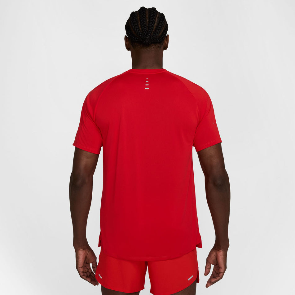 Back view of a model wearing the Nike Men's Stride Dri-FIT ADV Short-Sleeve Running Top in the University Red/Reflective Silver colourway. (8560170762402)