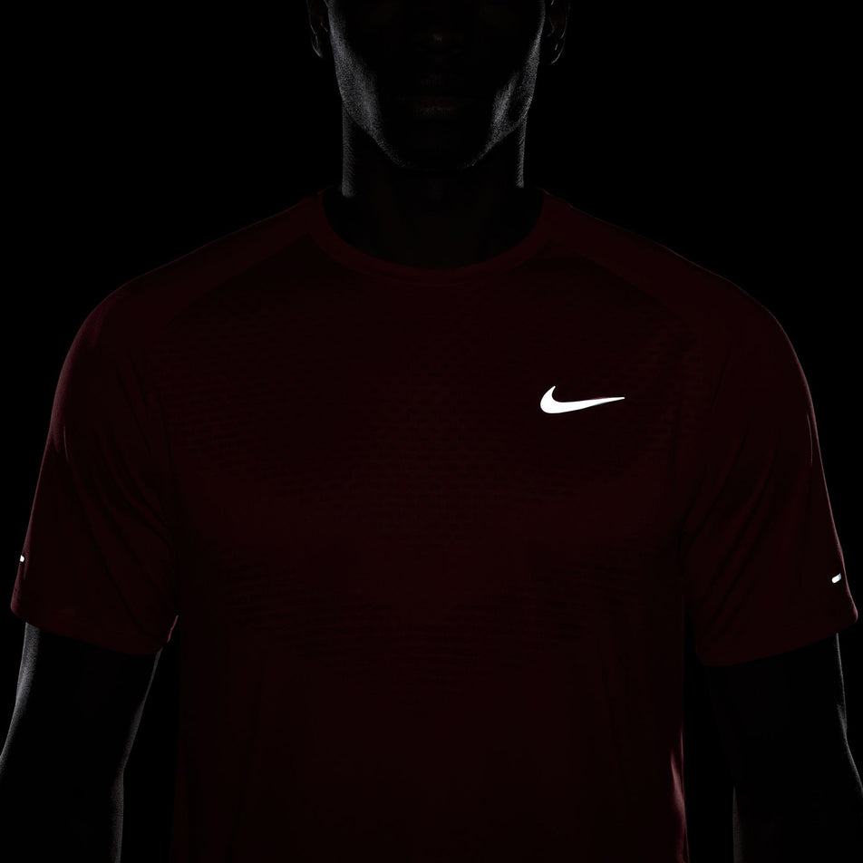 The reflective Swoosh on the front of the Nike Men's Stride Dri-FIT ADV Short-Sleeve Running Top in the University Red/Reflective Silver colourway. (8560170762402)