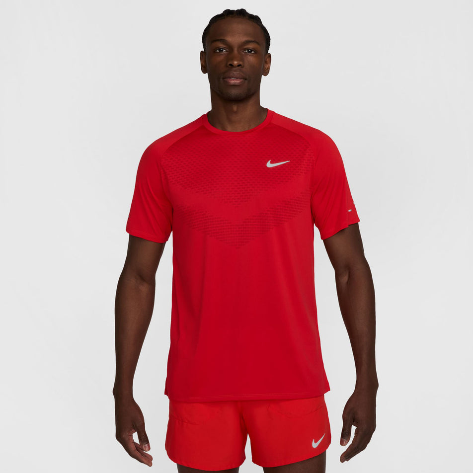 Front view of a model wearing the Nike Men's Stride Dri-FIT ADV Short-Sleeve Running Top in the University Red/Reflective Silver colourway. (8560170762402)