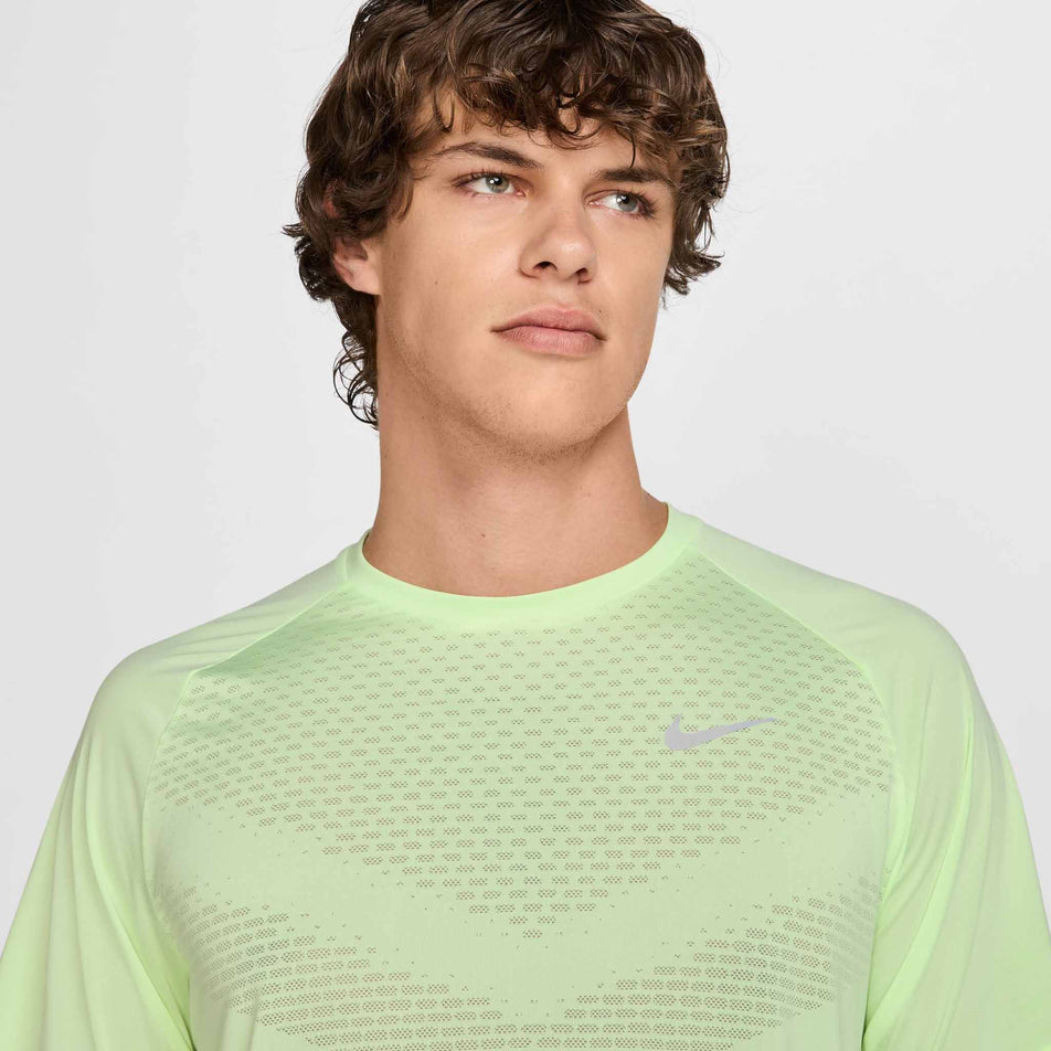 Close up view of the chest area of the Nike Men's Stride Dri-FIT ADV Short-Sleeve Running Top in the Barely Volt/Reflective Silver colourway. (8560175513762)